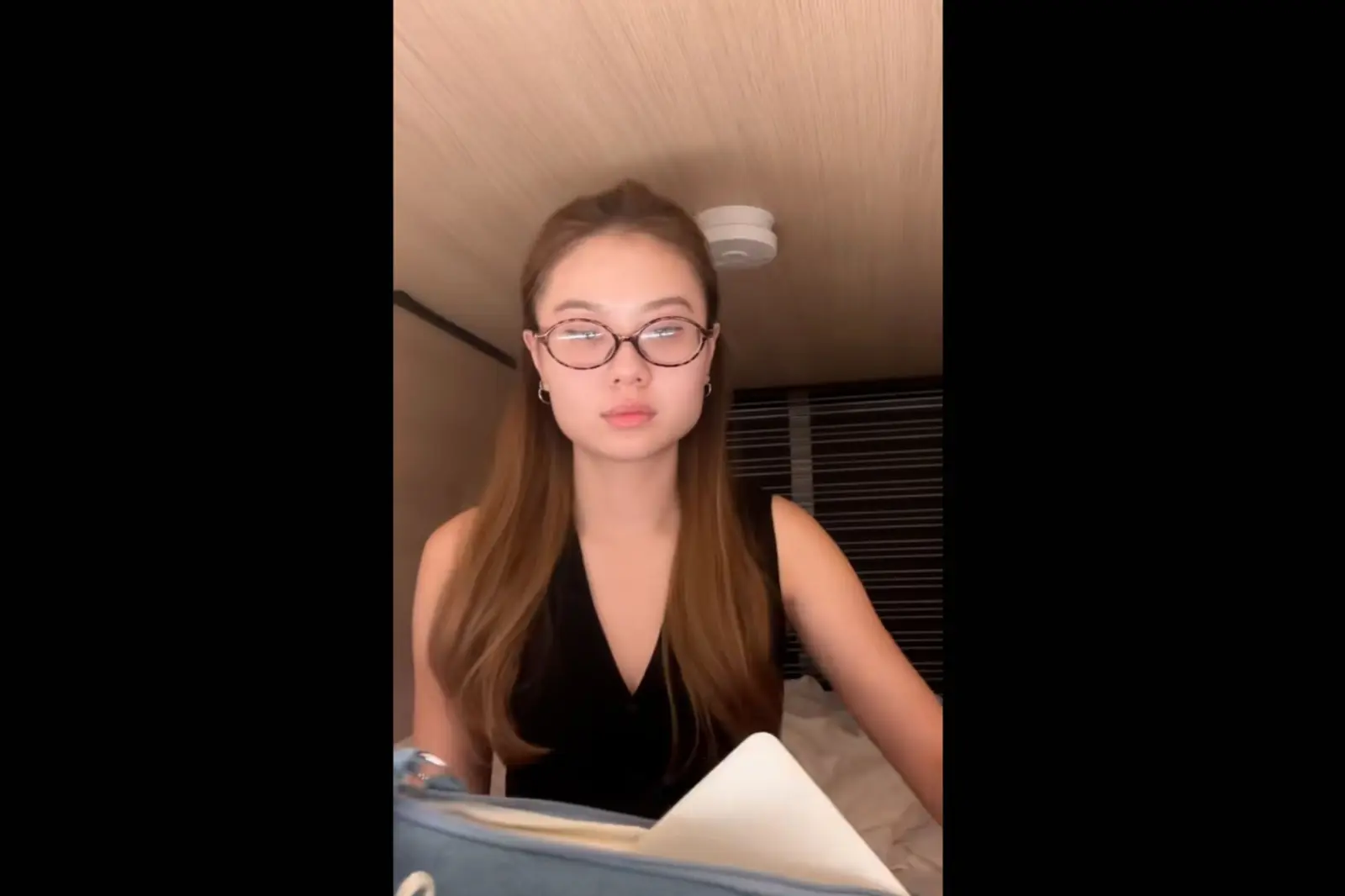 A screenshot of a woman from a viral video TikTok video about a worker who lives in a pod hotel a few times a week to cut down her commuting costs.